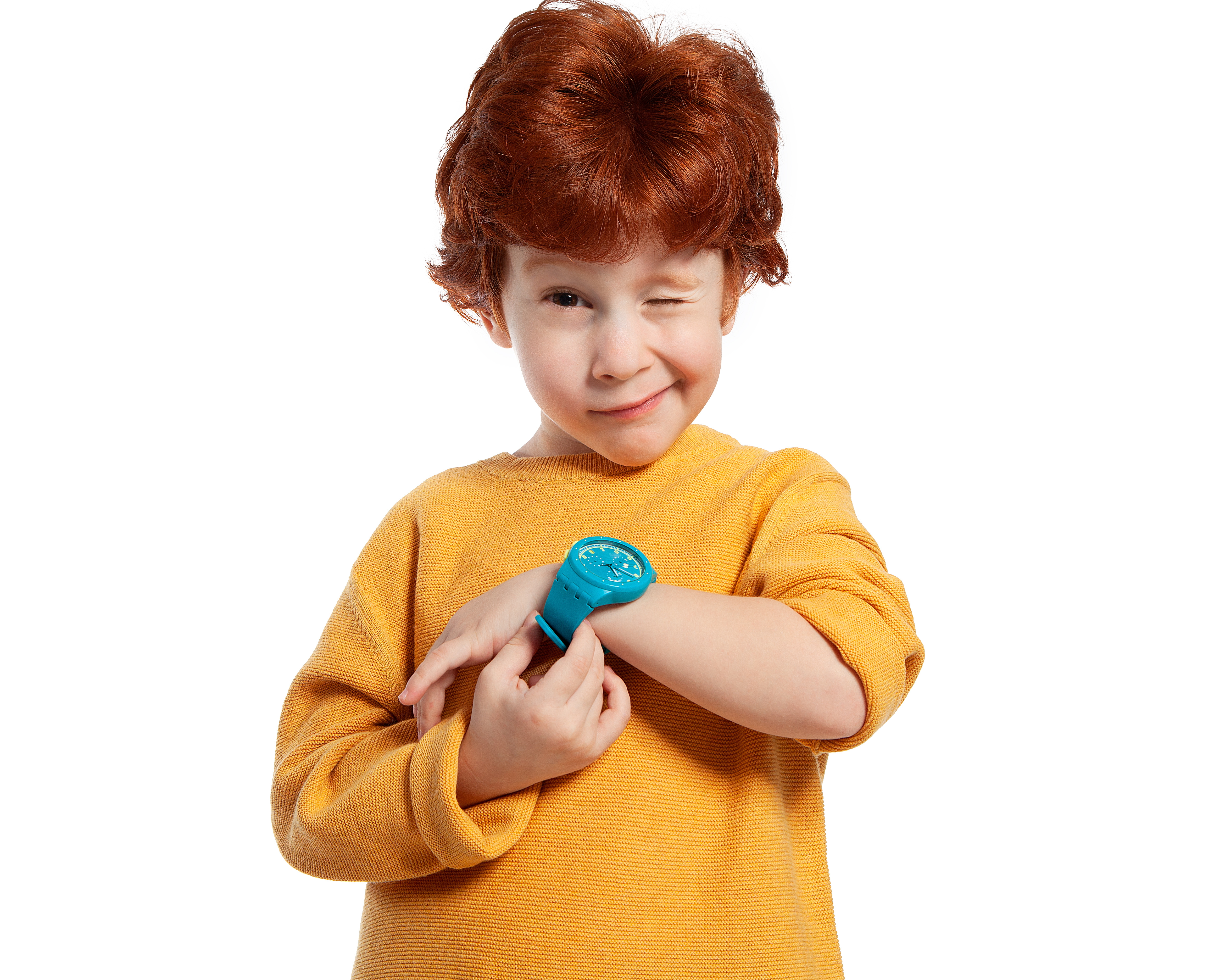 Black and white image of toddler-aged boy with short dark hair holding a watch and winking at the camera. 