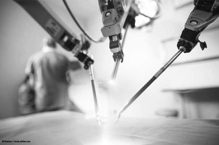 A close-up view of robotic surgical arms performing a procedure on an operating table. The background shows a blurred medical professional, highlighting the use of advanced technology in minimally invasive surgery.