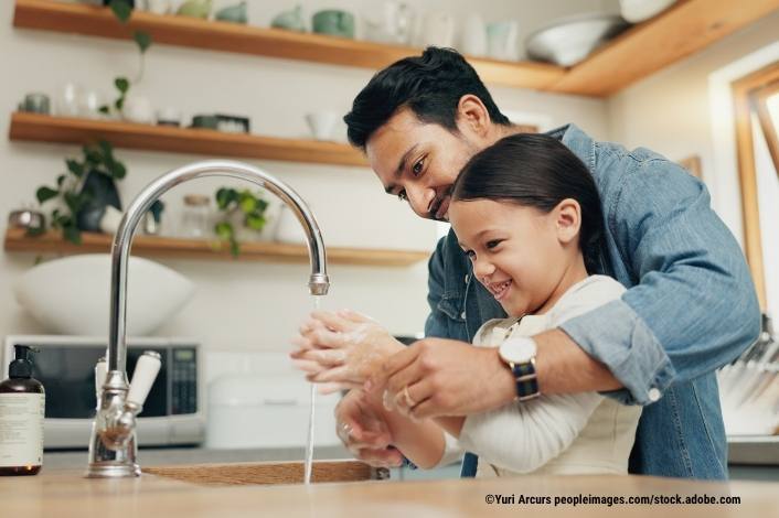 Father and daughter washing their hands.