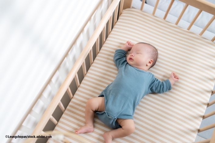 baby sleeping on back in crib