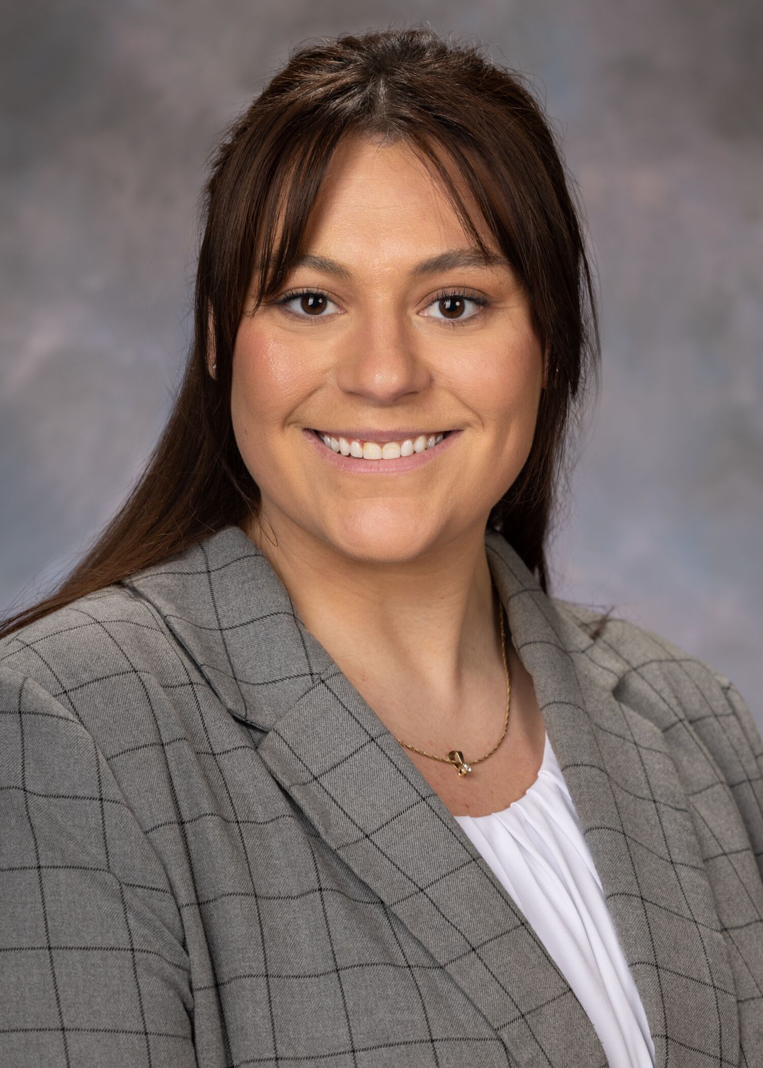 Portrait of Annie Truelove, woman with long brown hair and grey blazer.