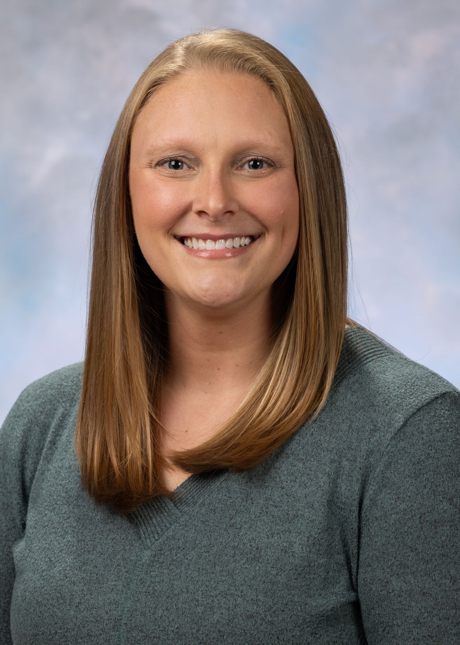 Portrait of Erika Roberts, woman with long blonde hair and a grey shirt.