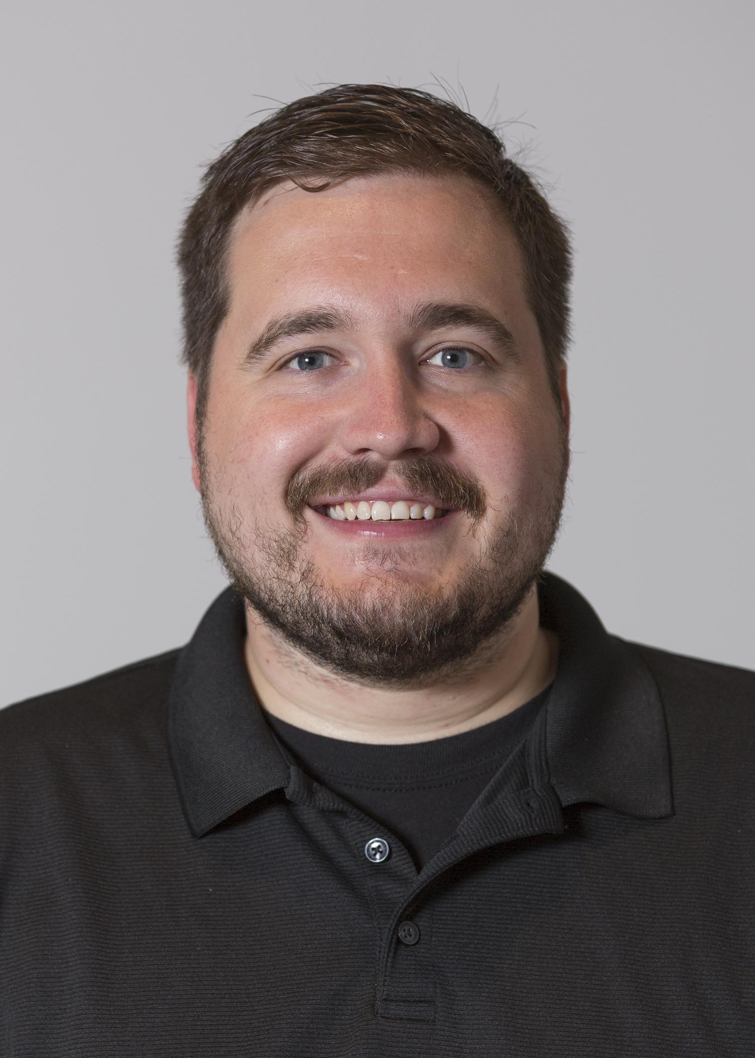Portrait of Grant Heydinger, man with brown hair and beard and a black shirt.