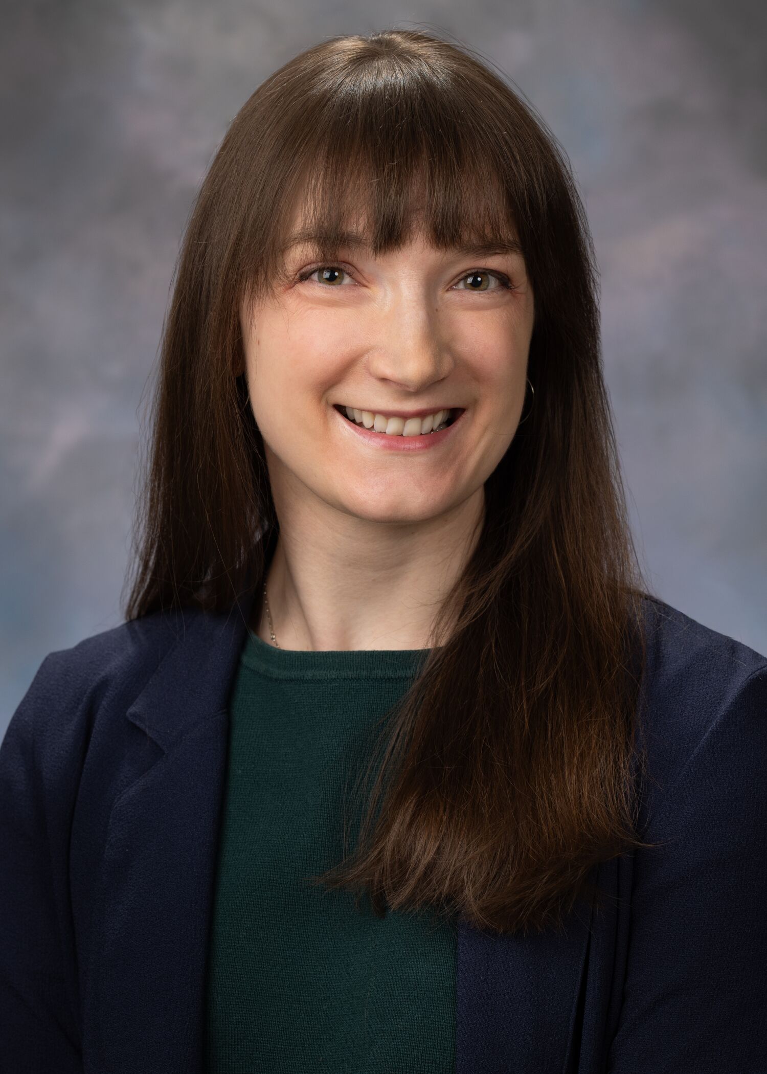 Portrait of Hannah Barton, woman with long brown hair and a green shirt.