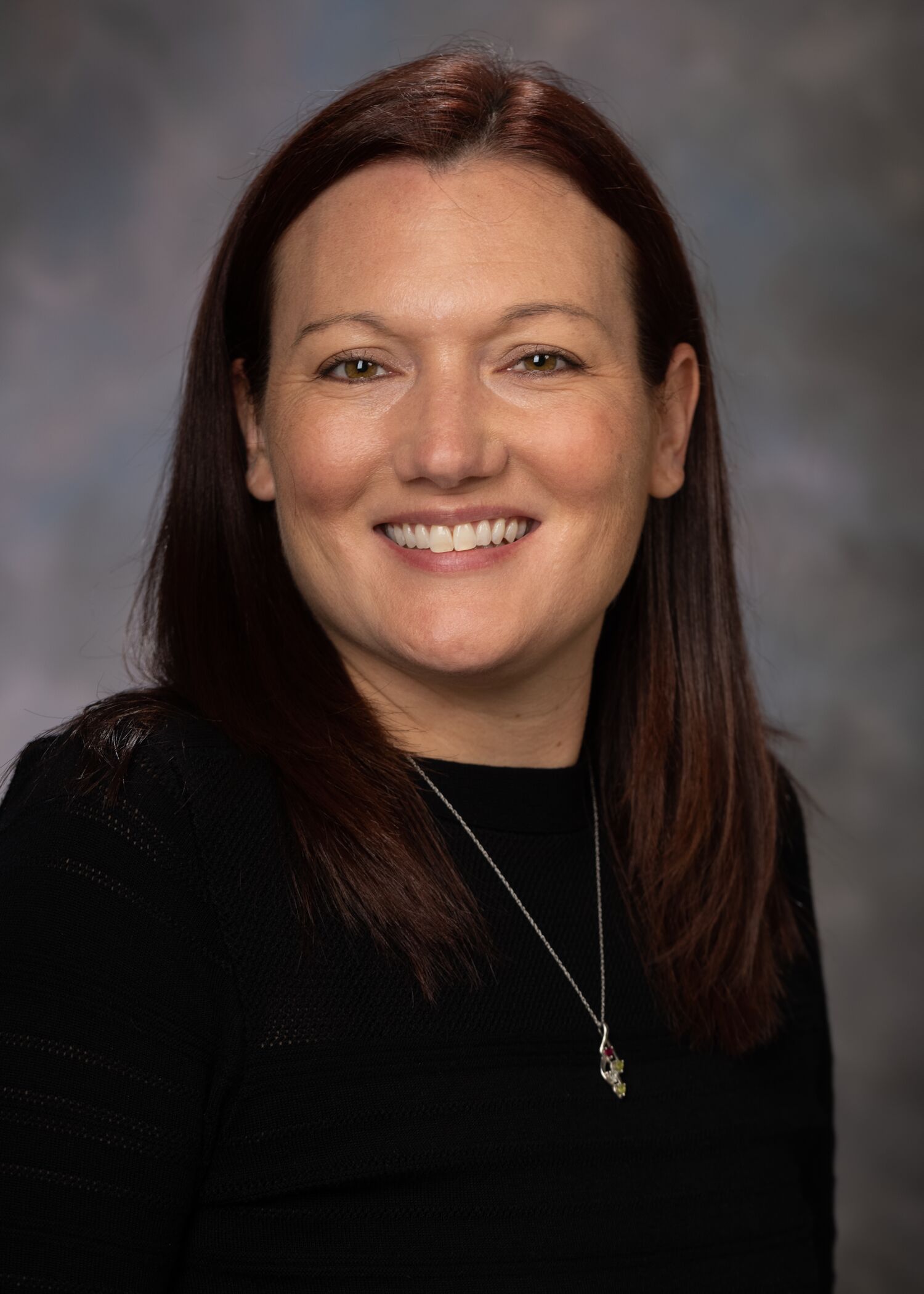 Portrait of Jessica Laubensheimer, woman with long brown hair and a black shirt.