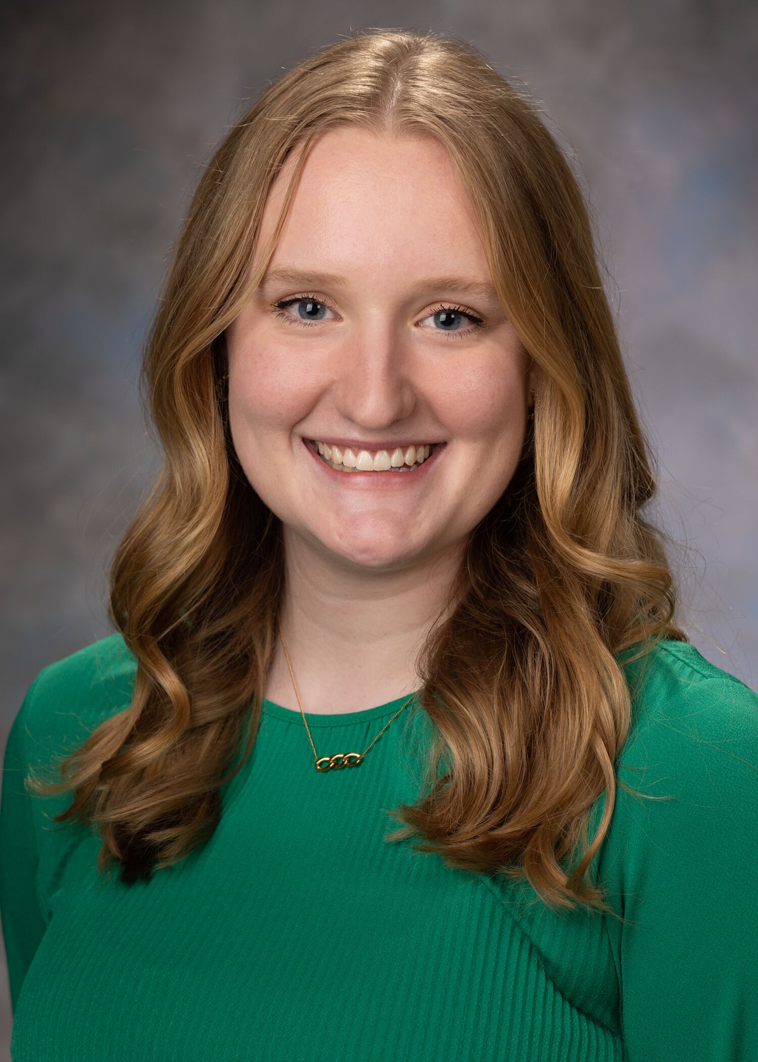 Portrait of Katie Donovan, woman with long blonde hair and a green shirt.