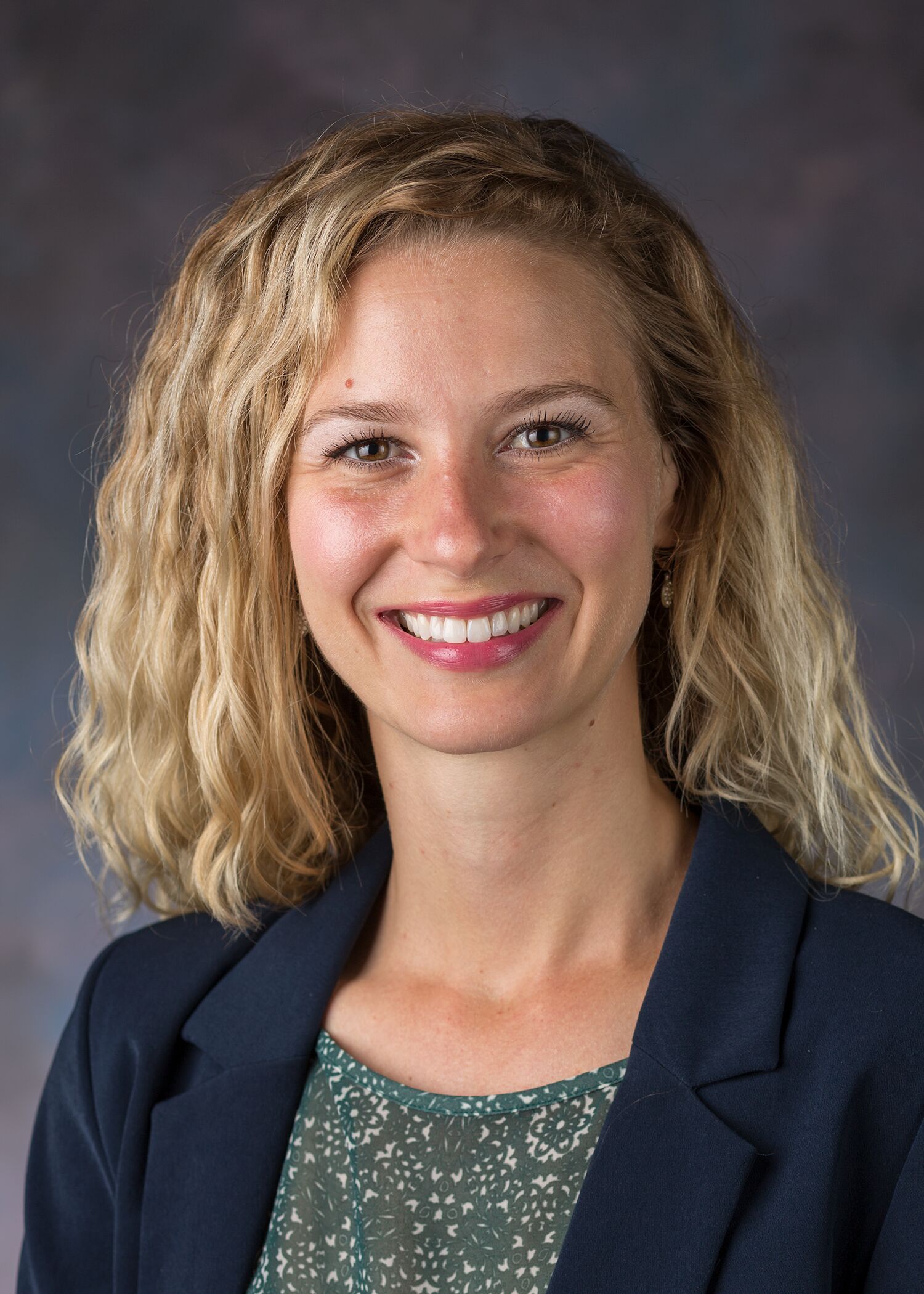 Portrait of Kayla Zimpfer, woman with long blonde hair and a blue blazer.