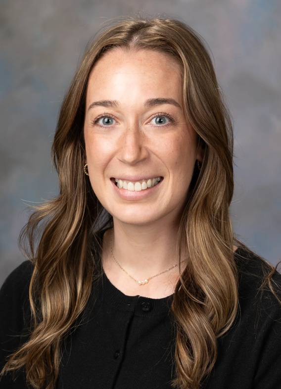 Portrait of Megan Stanley, woman with long brown hair and a black shirt,