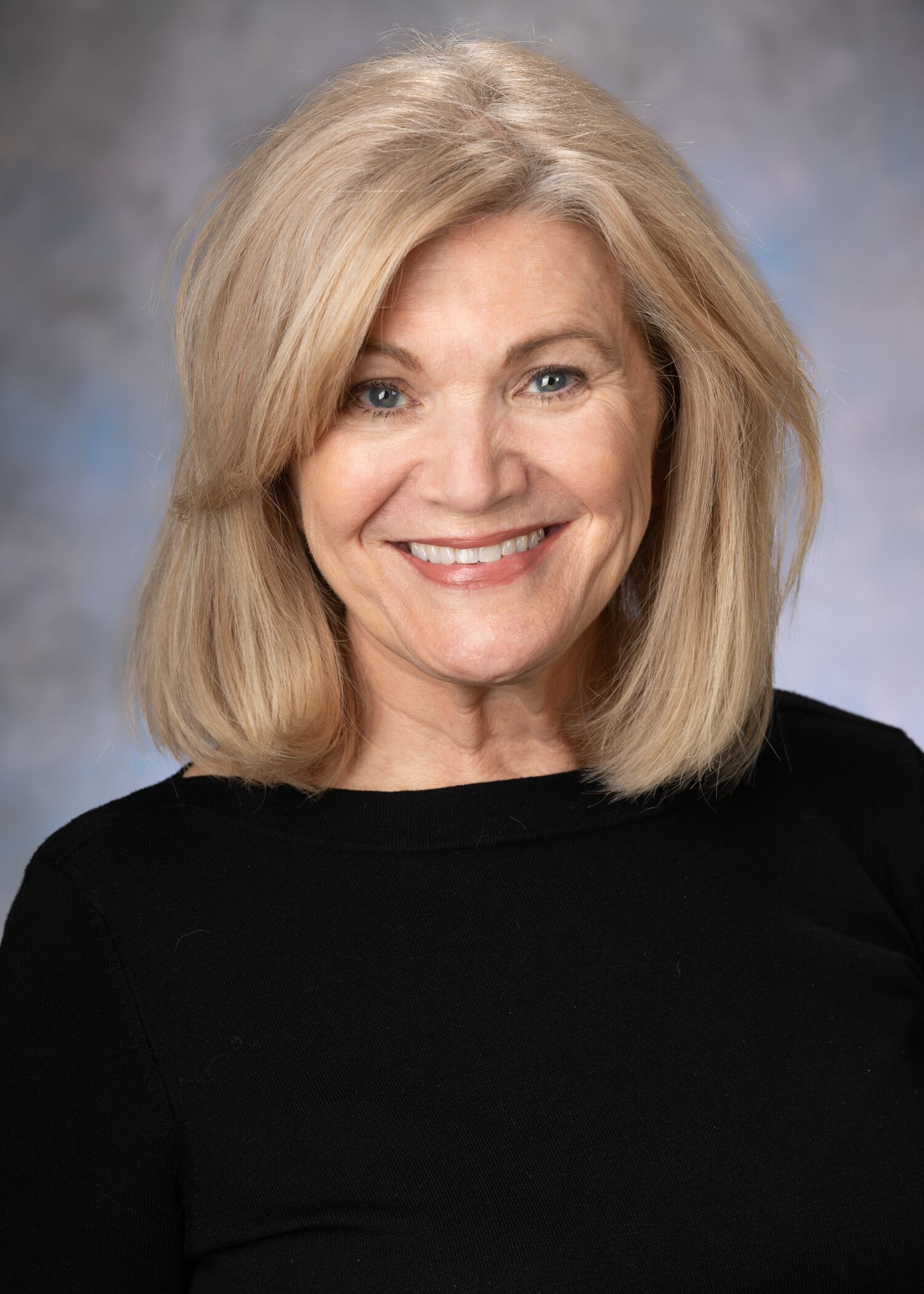Woman with short blonde hair and a black shirt.