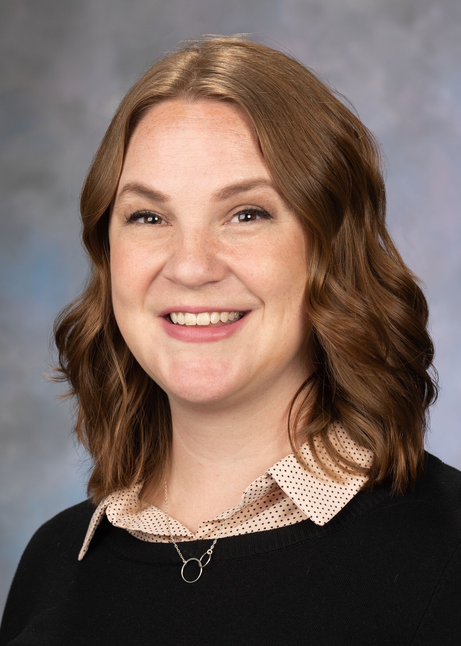 Portrait of Sarah Scott, woman with short brown hair and a black shirt.
