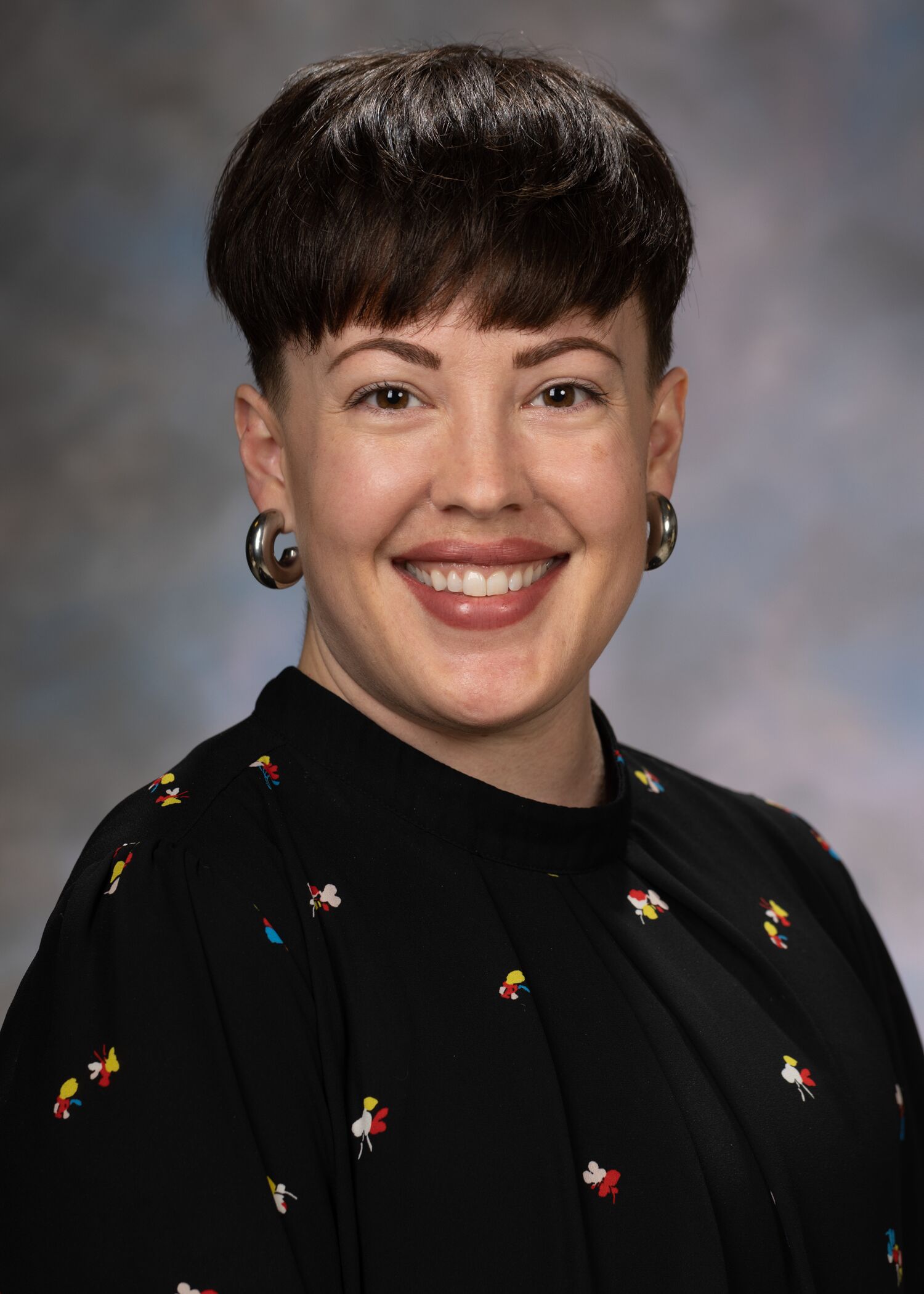 Portrait of Tabi Evans, woman with short brown hair and a black shirt.