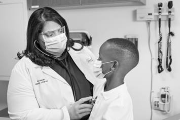 A provider examines an elementary student at a school-based health location