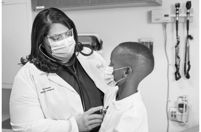 A provider examines an elementary student at a school-based health location