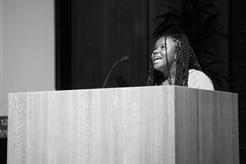A high school student is speaking at a podium