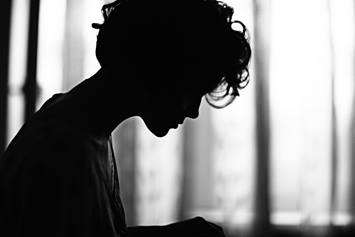 Side profile of a teenager, looking solemn