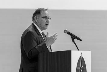 Nationwide Children's CEO Tim Robinson is shown standing at a podium, speaking at a groundbreaking ceremony