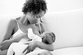 A Black mother is breastfeeding her infant