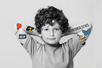 Elementary age boy with hands resting behind his head.