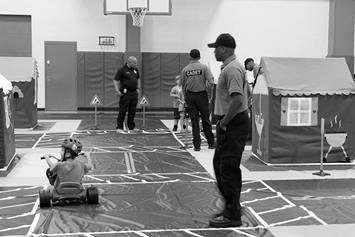 Cadets with Safety City participants in an indoor gymnasium setting