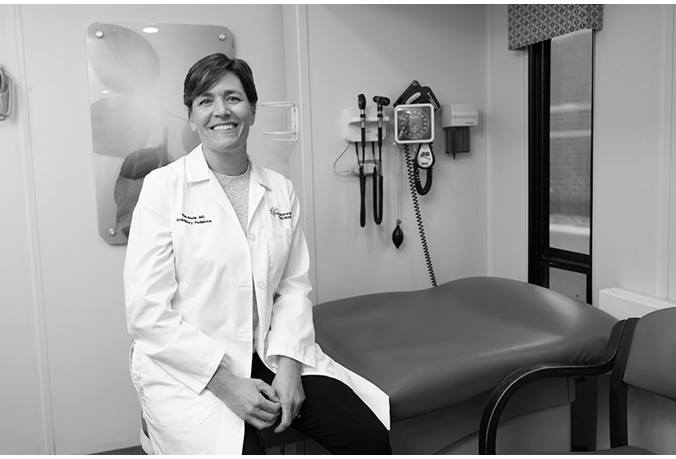 Dr. Bode is shown wearing a white coat, sitting in a mobile care center.