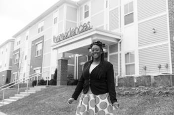 An employee stands in front of the Residences at Career Gateway