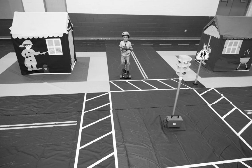 Young child in a gym, playing on an obstacle course.