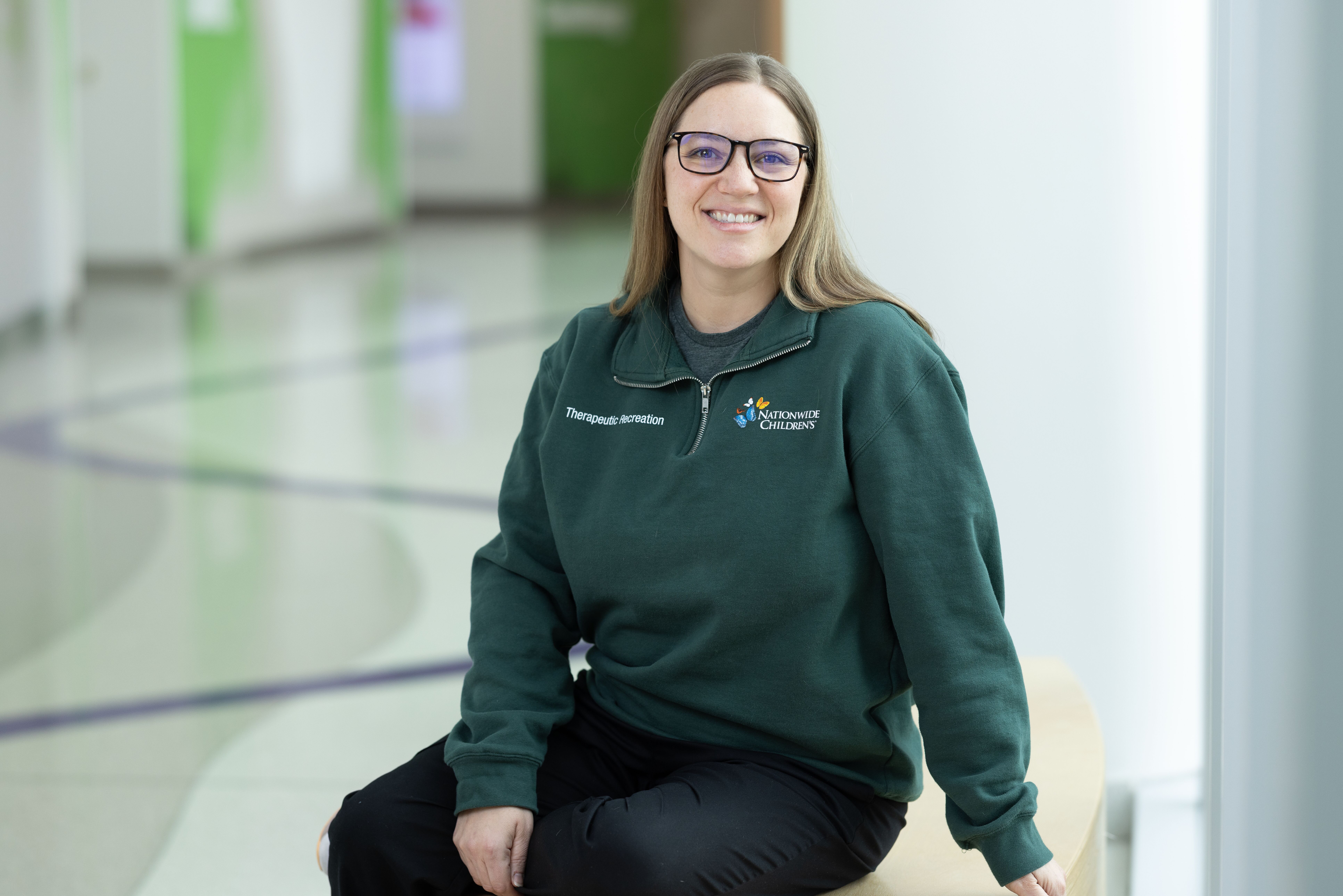 Nationwide Children's employee sitting on bench in hallway