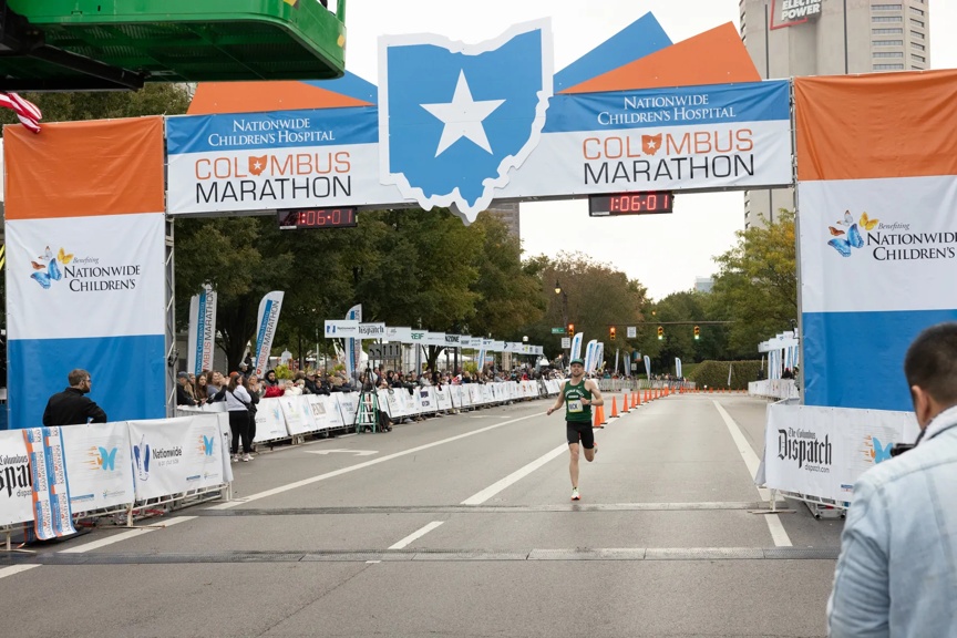 Runner crossing the finish line in the Columbus Marathon