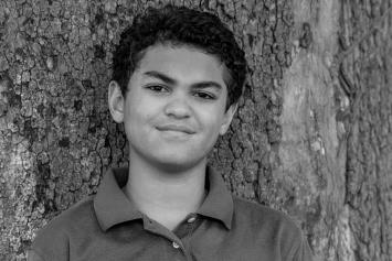 Pre Teen Boy Standing by a Tree