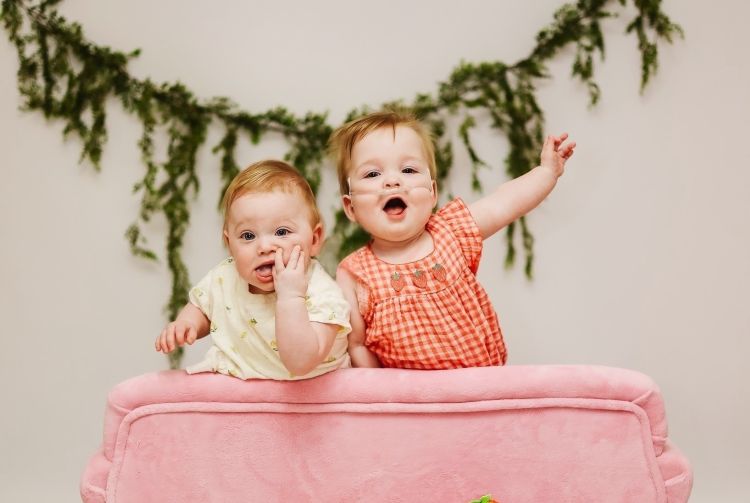 Addie and Millie on a pink couch