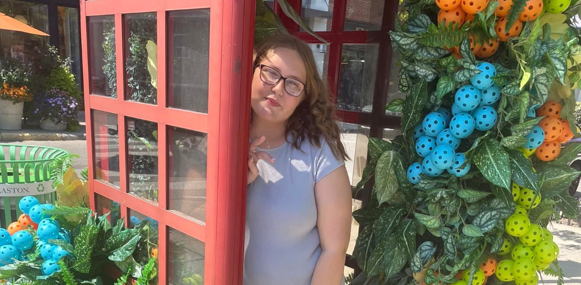 bethany in a red phone booth surrounded by flowers