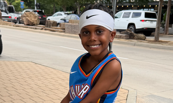young boy with Nike headband smiling
