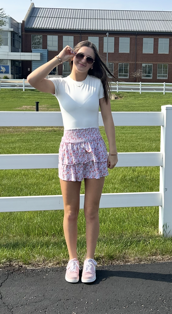 Madi standing outside smiling with sunglasses on