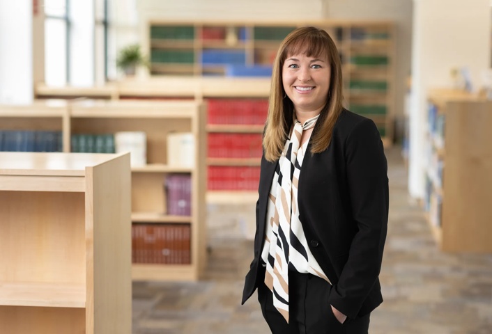 Amy Tyler, MD, is standing in a medical library at Nationwide Children's Hospital