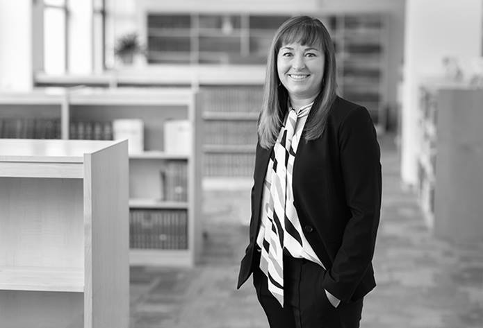 Amy Tyler, MD, is standing in a medical library at Nationwide Children's Hospital