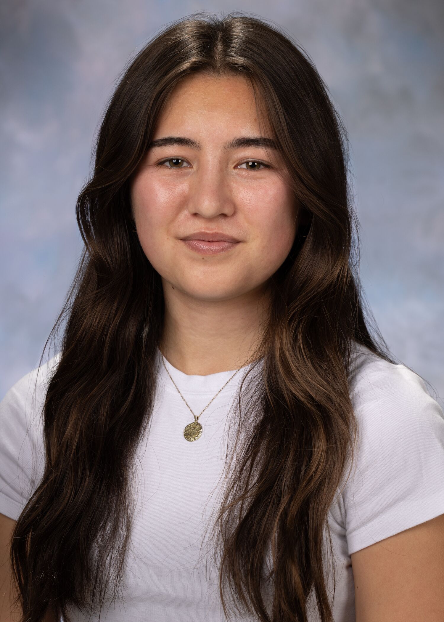 Portrait of Danielle Dresher. Danielle has long dark hair and is wearing a white short-sleeved shirt.