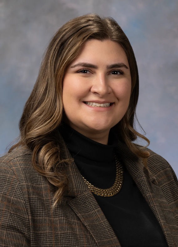 Portrait of Marissa Kreutzer. Marissa is wearing a black turtleneck shirt with a brown blazer. 