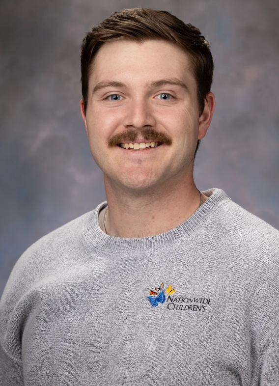 Portrait of Nick Wile, man with short brown hair and mustache, and a grey shirt.