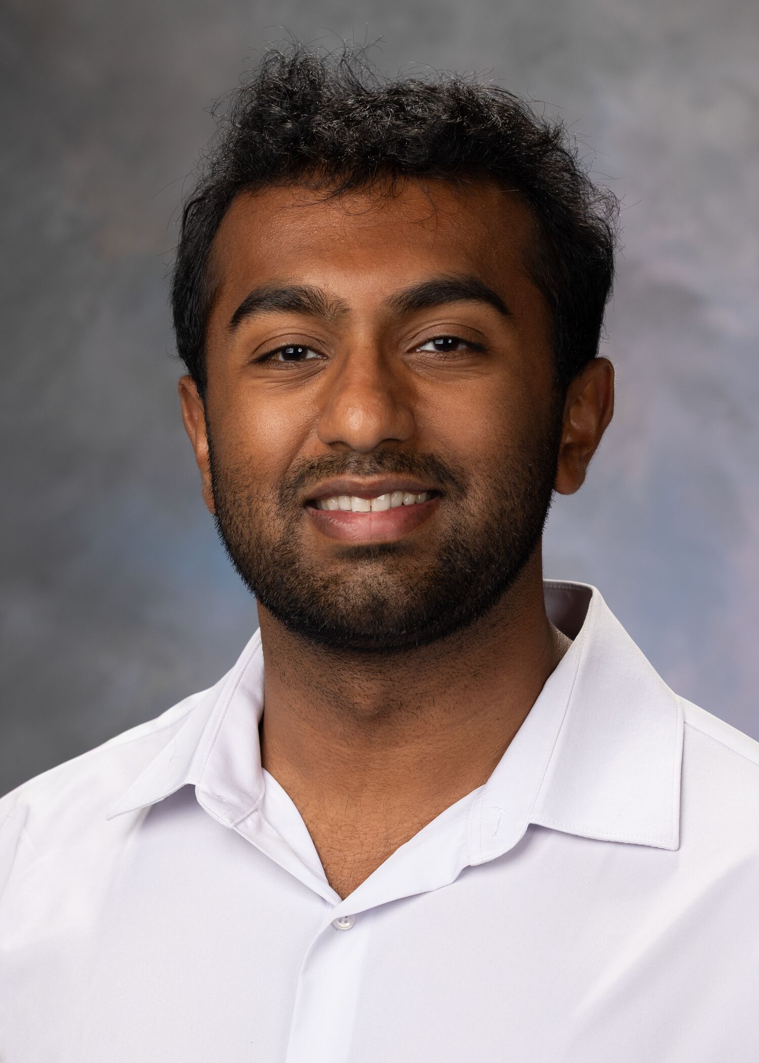 Portrait of Srujan Jaladi. He has short brown hair and is wearing a white dress shirt.