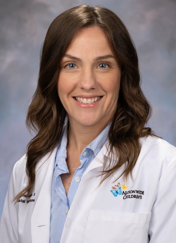 Portrait of Stephanie Medernach, woman with long brown hair and a white lab coat.