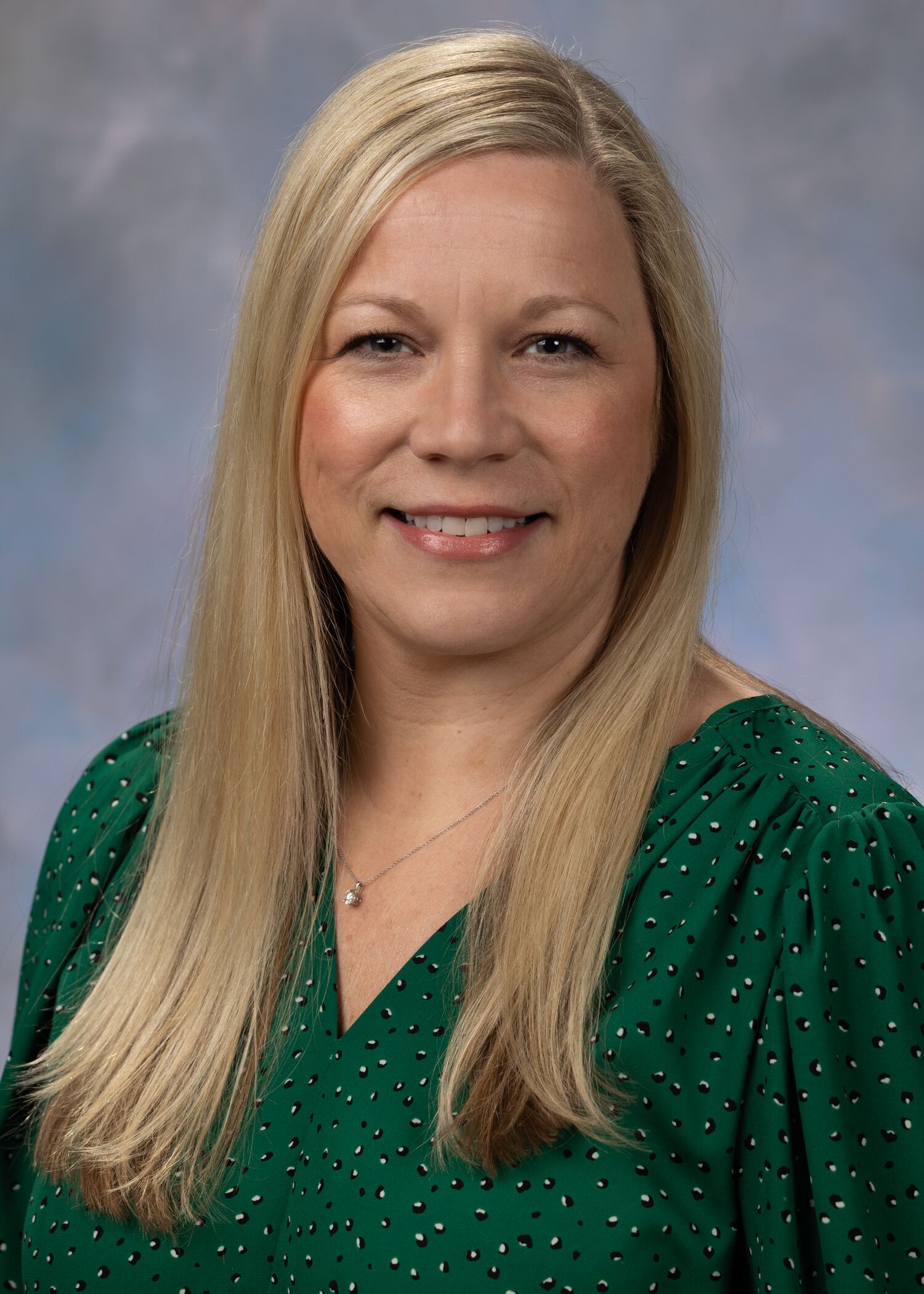 Portrait of Stephanie Townsend. Stephanie has medium length blonde hair and is wearing a green top. 