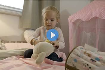 CCPR patient, Lily, in her room playing with a stuffed animal.