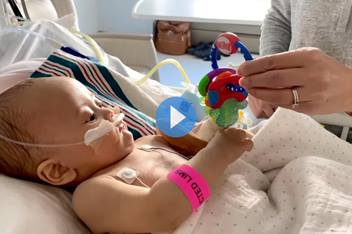 CCPR patient, Malakai, playing with some toys while in his hospital bed.