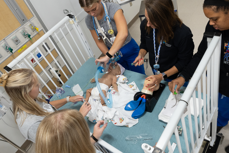 Nurses practicing on a fake baby doll