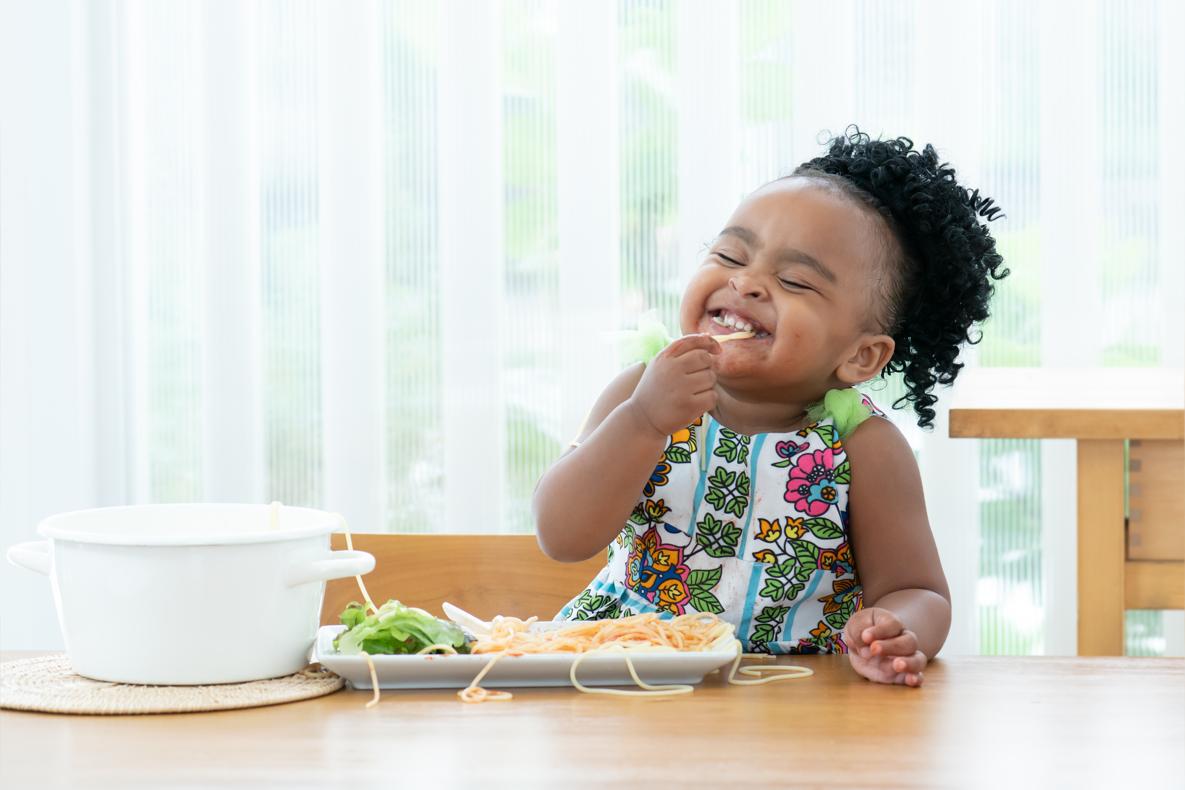 young girl eating pasta