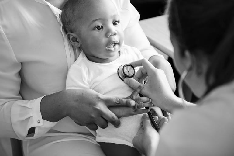 Physician listening to child's heart