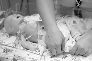 A provider running through a neonatal simulation with a fake baby.