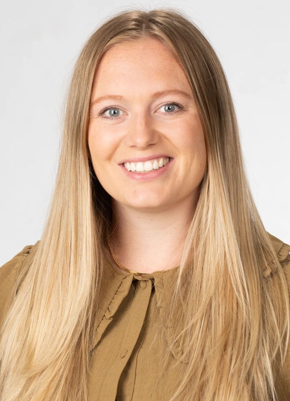 Portrait of Allanah King, woman with long blonde hair and a brown shirt.