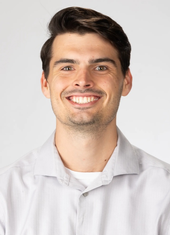 Portrait of Austin Rush, man with short brown hair and a white shirt.