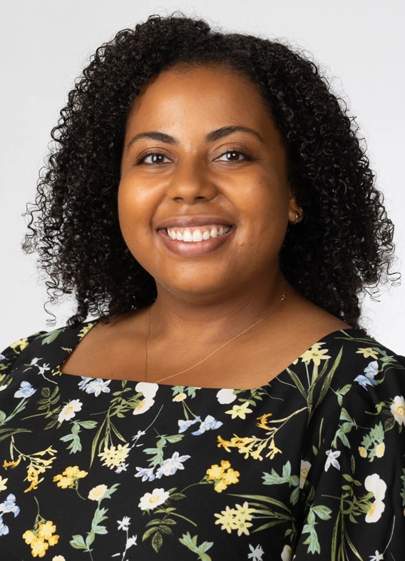 Portrait of Carmen Stone, woman with long black hair and a floral black shirt.